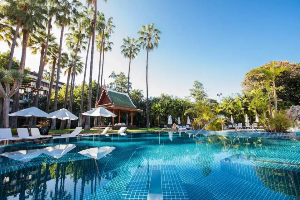 Det vakre bassengområdet på Hotel Botanico & The Oriental Spa Garden, omgitt av palmer, frodig grønt og en elegant asiatisk-inspirert paviljong – et tropisk paradis på Tenerife. (Foto: Hotels.com) Midt blant frodige palmer og eksotiske omgivelser ligger Hotel Botanico & The Oriental Spa Garden, et av Tenerifes mest luksuriøse hoteller. Bildet viser et idyllisk bassengområde omgitt av høye palmer, grønne planter og avslappende solsenger. En elegant, asiatisk-inspirert paviljong tilfører en eksotisk touch og speiler hotellets anerkjente spa-konsept med inspirasjon fra Østens ro og velvære.Som en del av Tenerifes topp 5 hoteller er Hotel Botanico kjent for sin avslappende atmosfære, prisbelønte spa og eksepsjonelle service. Det er et perfekt sted for gjester som ønsker å kombinere luksus med fredelige omgivelser, omgitt av frodig natur og Tenerife sitt solfylte klima.Dette hotellet er et paradis for både kropp og sjel – hvor tropiske vibber møter luksuriøs eleganse.