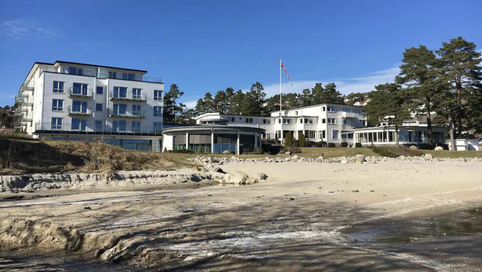 Strand Hotel Fevik er et velkjent badehotell fra 1937 bygd av Axel Lund. (Foto: Hotels.com) Strand Hotel Fevik er et stort hvitt hotell som ligger på stranden.