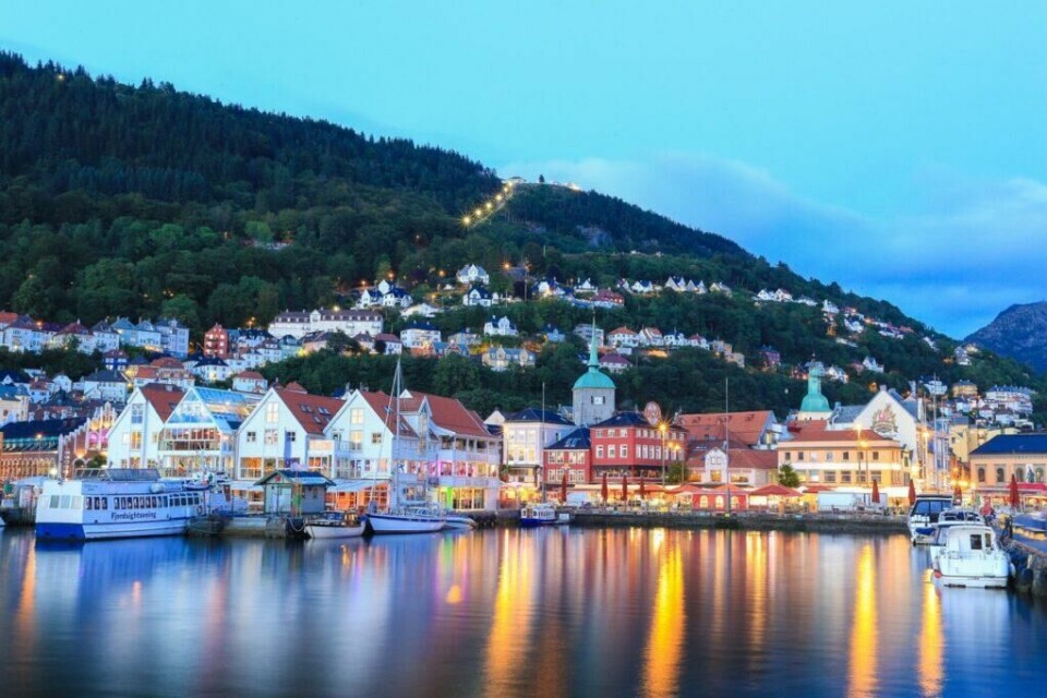 Zachariasbryggen er en utstikkerkai i Vågsbunnen, med navn etter kjøpmann Zacharias Weigner (død 1737). (Foto: Visit Bergen / Girish Chouhan - visitBergen.com) Zachariassbryggen i Bergen en kveld, med lys fra de fargerike samt hvite trehusene på bryggen. Fløybanen i bakgrunnen.