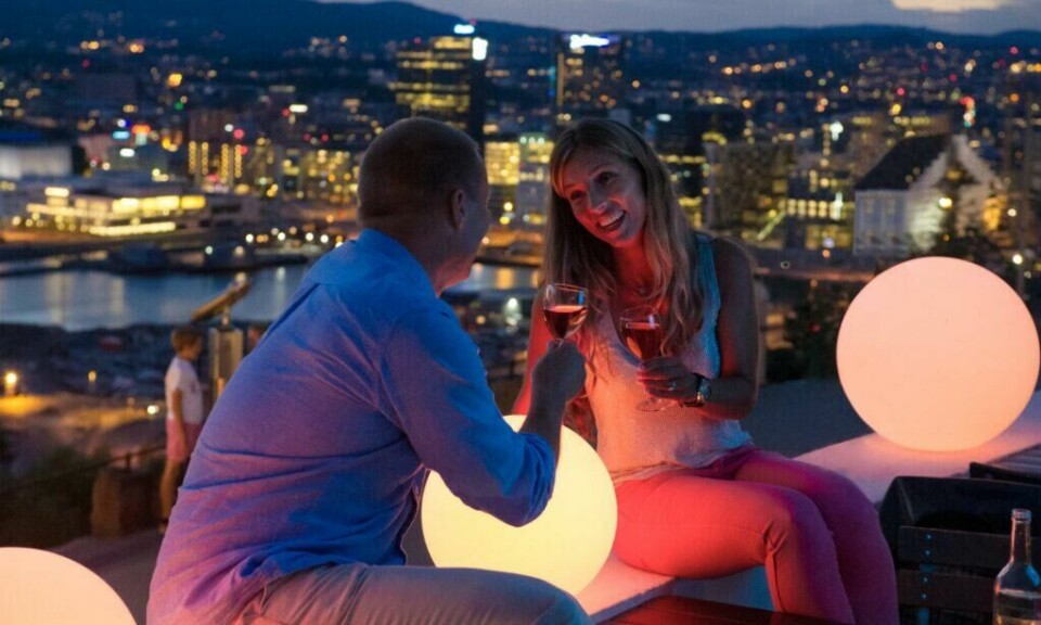 Ekebergrestauranten holder til i et historisk funkisbygg med praktfull utsikt over byen og Oslofjorden. (Foto: CH / VisitNorway) Bilde av par som nyter vin med utsikt over Oslo på Ekebergrestauranten.