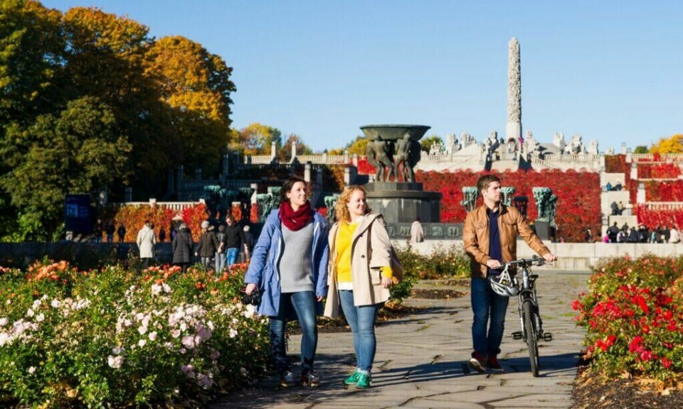 Frognerparken er Norges mest besøkte severdighet. Her ligger blant annet den berømte Vigelandsparken med over 200 av Gustav Vigelands skulpturer. (Foto: CH / Visit Norway) Spaserende damer og mann med sykkel i Vigelandsparken, med monolitten i bakgrunnen, i Oslo en solskinnsdag.