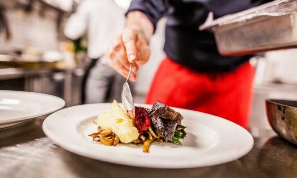 Bergen har status som UNESCO gastronomiby. (Foto: Martin Håndlykken / Visit Norway) Bilde av hender som legger mat på et fat på en restaurant i Bergen.