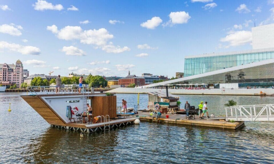 Det er flere saunatilbud i tilknytning til Oslofjorden, som her ved Sørenga like ved siden av Operhuset. (Foto: Didrick Stenersen / VisitOslo) Sørenga i Oslo med bilde av Oslofjorden, bygg og Operaen. Personer som bader og går på flytebrygge med badstue og stupetårn.