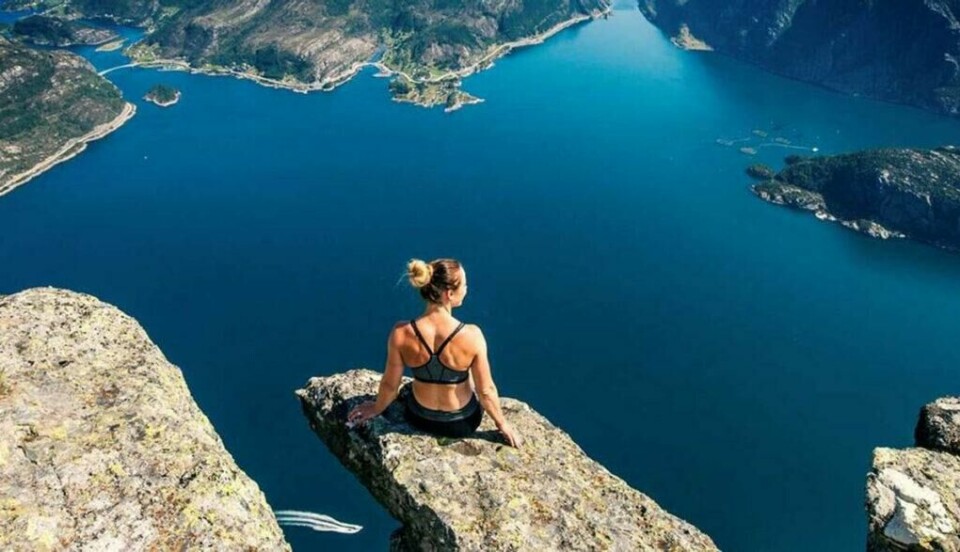 Hornelen i Bremanger er Europas høyeste fjellklippe. Fra toppen har du god oversikt over Nordfjord (Foto: Fjordkysten.no) Kvinne på tuppen av Hornelen i Bremanger, Norge. En fjelltur med fantastisk utsikt over hav.