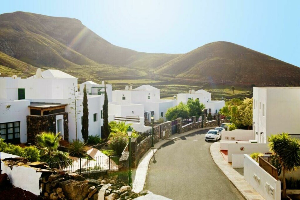 Lanzarote er en vulkanøy med over 150 000 innbyggere med fantastisk lavalandskap og vakre strender. (Foto: Apollo) Hvite hus på gate ved bare fjell på Lanzarote