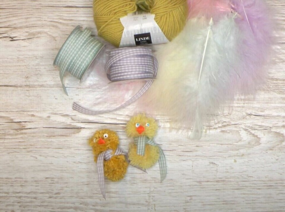To søte påskekyllinger klare til påske! (Foto: Kreativeideer.no) To søte, gule påskekyllinger, ferdige med hvert sitt rutete bånd rundt halsen og utstyr på bord.