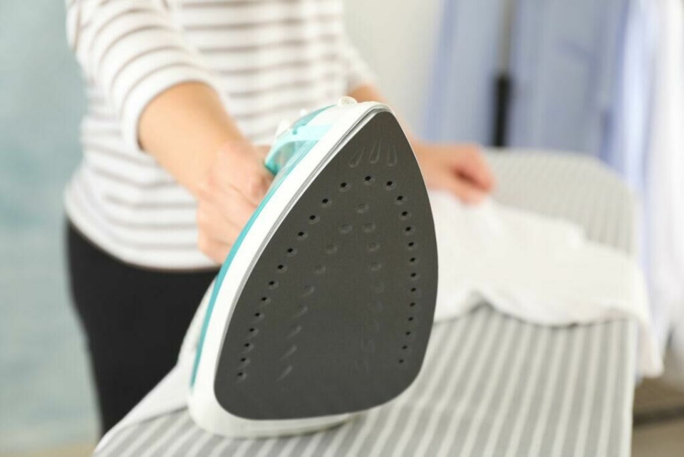 Linskjorter tåler ikke høy varme. Det kan derfor være lurt å fukte skjorten før du stryker. På den måten er det enklere å bli kvitt rynkene i stoffet. (Foto: Colourbox) Strykejern med hvit skjorte bak.