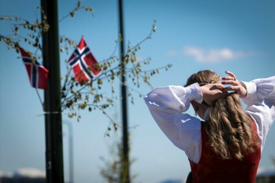 Har bunadskjorten broderier, som her på mansjettene på skjorten er det viktig at du ikke stryker direkte på disse. (Foto: Colourbox) Bilde av jente i bunad foran lyktestolpe med norske flagg på 17. mai.