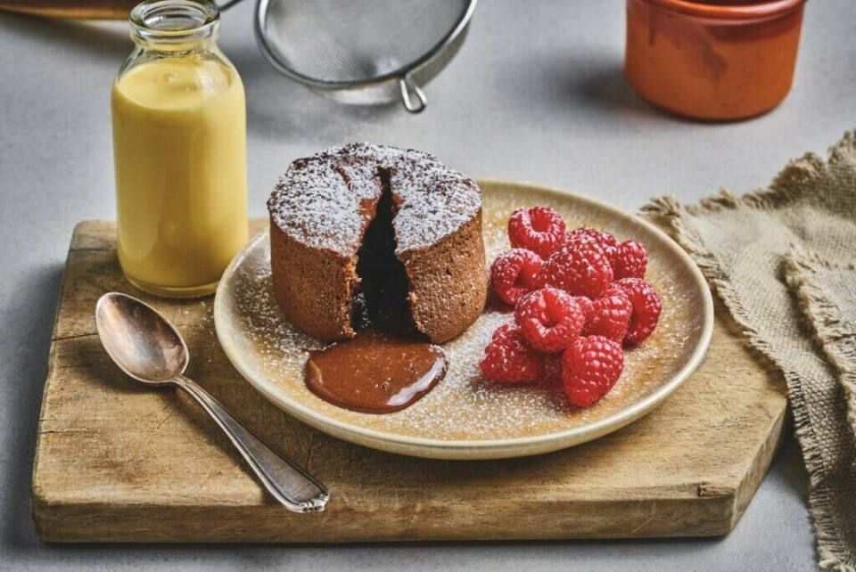 Visste du at du til og med kan lage sjokoladefondant i airfryer og at det kun tar 4 minutter? (Foto: Foodie.no) Sjokoladefontant med bringebær på en tallerken på en fjøl med et glass appelsinjuice laget i airfryer.