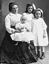 Belle Gunness sammen med barna Lucy, Myrtle og Philip. Bildet har ukjent datering, muligens 1904 eller 1905, ettersom Philip ble født i 1903. De tre barna ble alle funnet døde i kjelleren etter brannen 28. april 1908. Foto: Ukjent / Public Domain