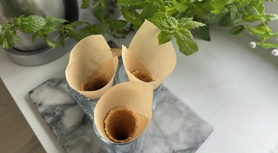 Et smart triks: Plasser kjeks i glass med bakepapir for enkel og sølefritt fylling av hjemmelaget kroneis. (Foto: Kreative Ideer/ Aurora Lange) Hjemmelaget kroneis starter med enkle forberedelser: vaffelkjeks plassert i glass og foret med bakepapir, klare til å fylles med iskrem og smakslag.